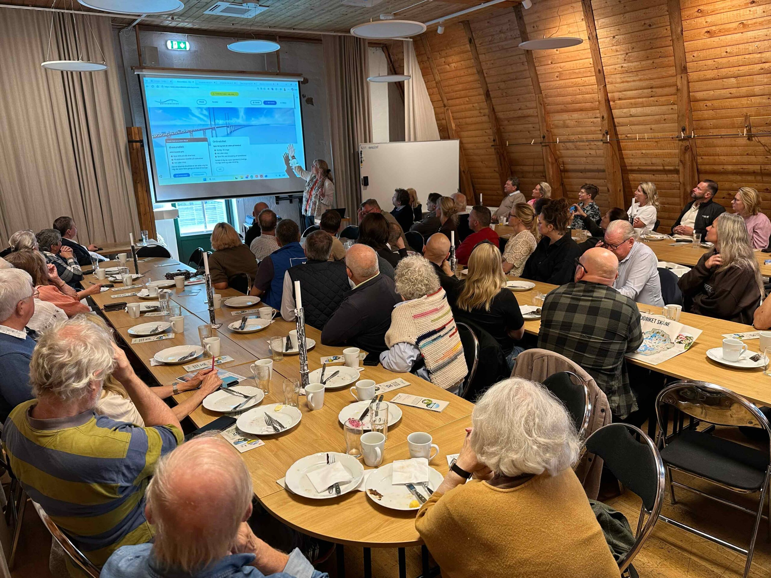 2026-08-31-foretagarfrukost-sjoriket-1-foto-julia-falkman Deltagare vid företagarfrukosten i Österslöv lyssnar på en presentation om Leaderprojektet Sjöriket Skåne.
