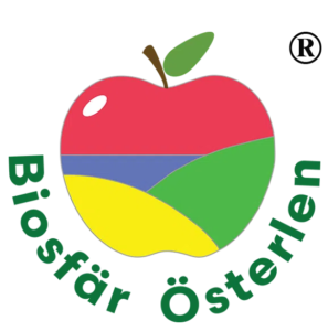 Logotyp för Biosfär Österlen med ett stiliserat äpple i rött, grönt, blått och gult samt texten ”Biosfär Österlen”.